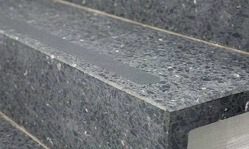 Speckled stone stair edge fitted with an anti-slip grip strip